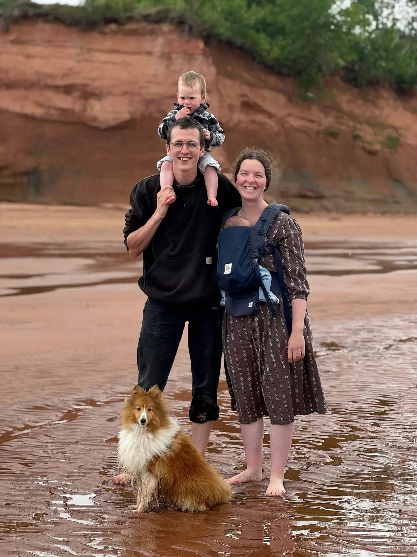 Cadel with his family and dog by a red sandstone shoreline